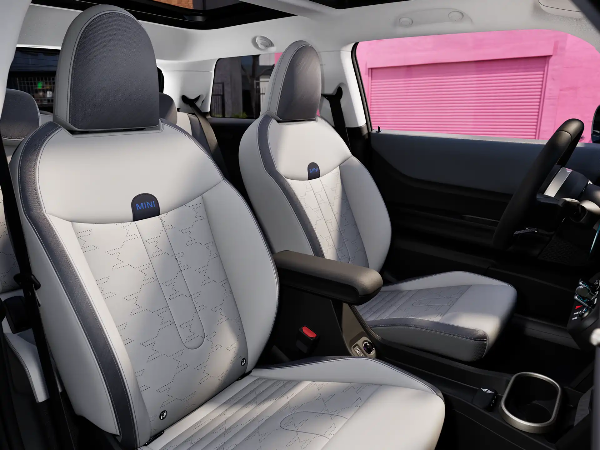 Unutrašnja perspektiva MINI Cooper-a sa komandnom tablom, volanom, okruglim ekranom, panoramskim staklenim krovom i zadnjim delom prednjih sedišta.