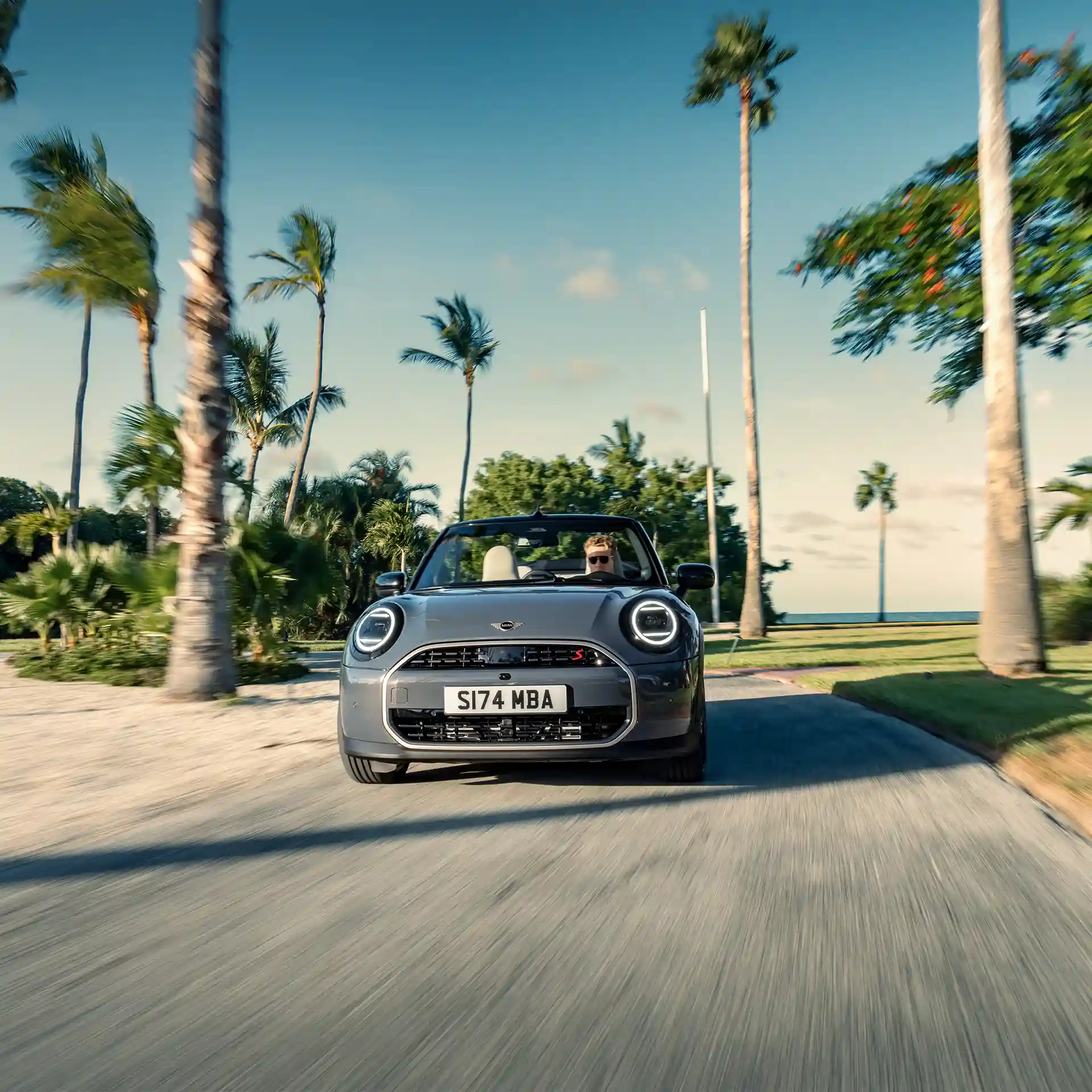 Prednji prikaz MINI Cooper Kabrioleta Copper sive boje tokom vožnje ulicom