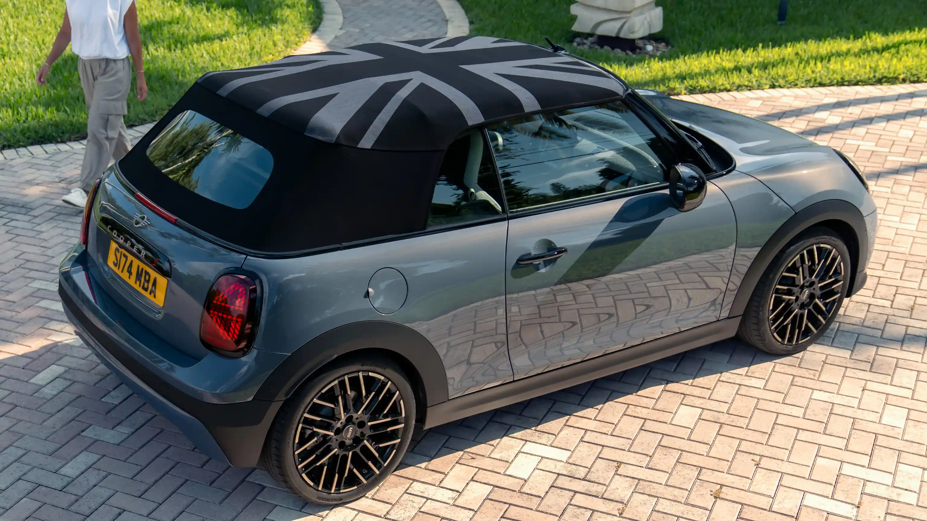 Prikaz bočne strane MINI Cooper Kabrioleta u Copper sivoj boji i sa MINI Vašim krovom (Yours Roof)
