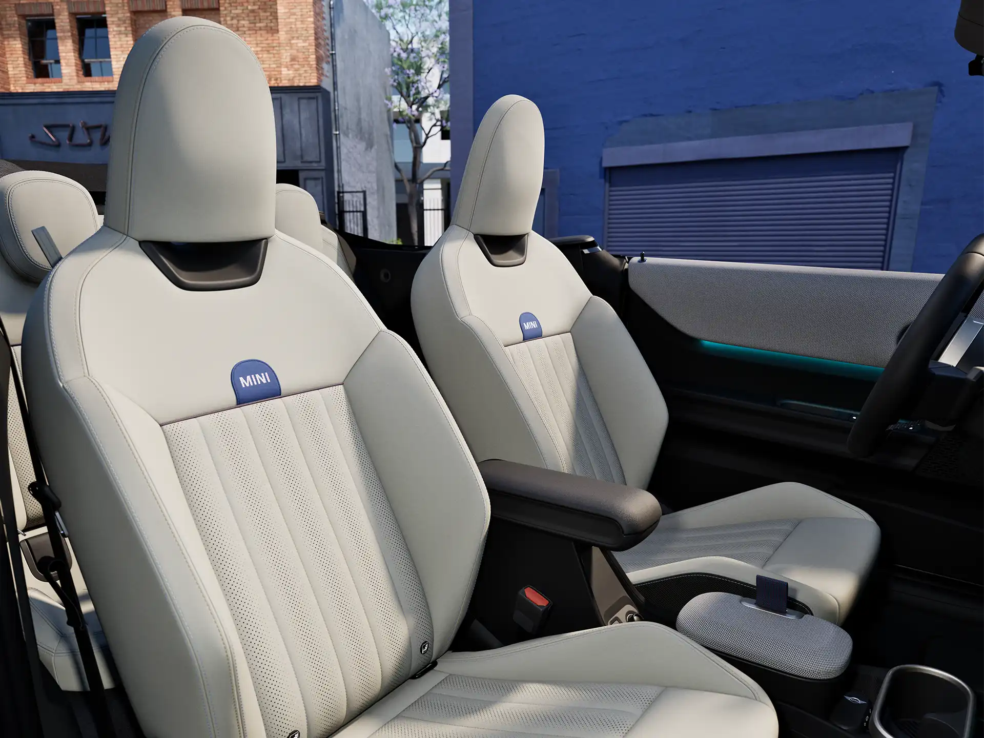Unutrašnja perspektiva modela MINI Cooper Kabiolet sa komandnom tablom, volanom, okruglim ekranom i zadnjim delom prednjih sedišta.