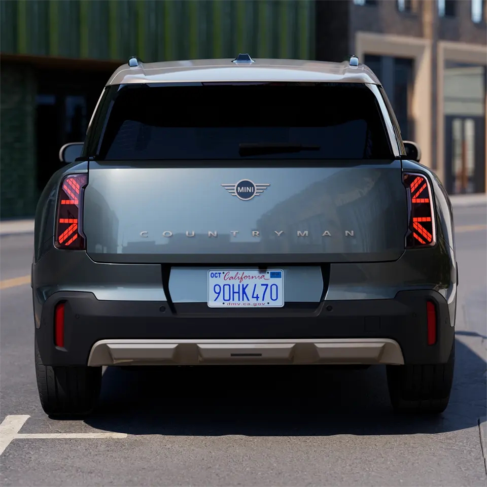 Prikaz zadnje strane MINI Countryman-a Smokey zelene boje sa živahnim srebrnim krovom tokom parkiranja